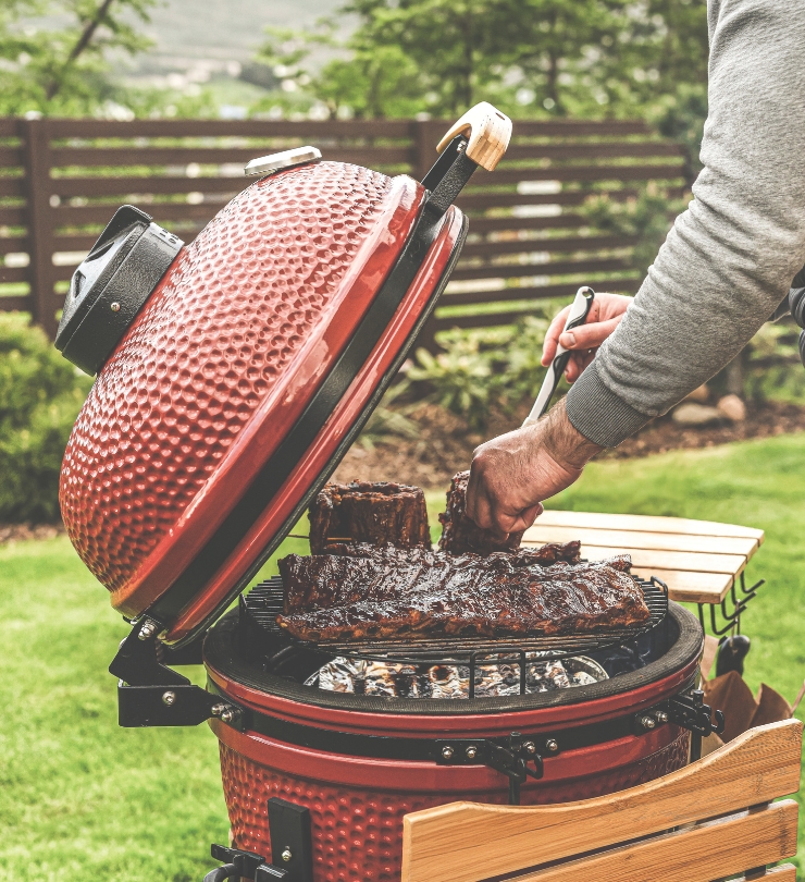 A man using a smoker in his back yard